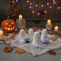 Halloween ghost face painting kit displayed on a tablecloth with a carved pumpkin, candles, autumn leaves, and string lights in the background.